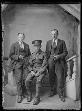 [Soldier in the Welsh Regiment wearing marksman skill-at-arms badge and flanked by two civilians]