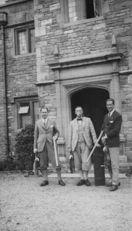 [A J Sylvester and two other men outside a large house]