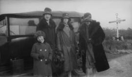 [Three women and a girl standing in front of a car]