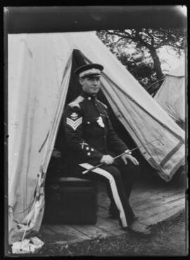 [Territorial Force soldier sitting outside a tent]